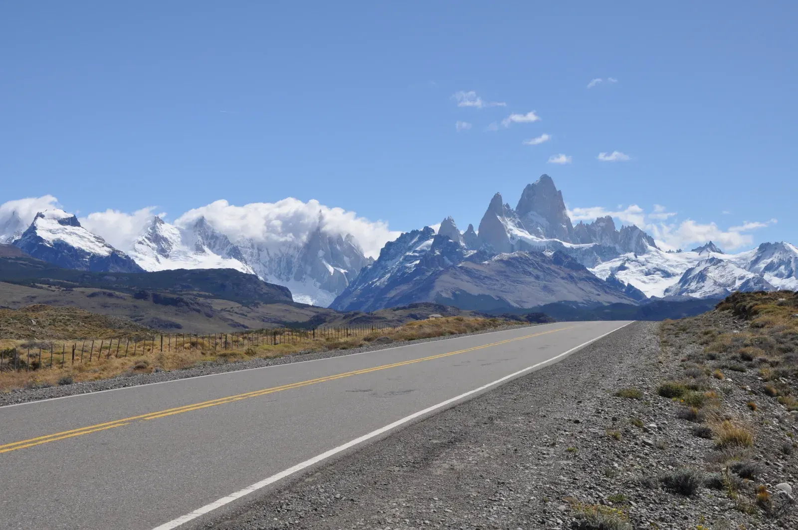 Asfaltweg door het steppelandschap van Patagonië richting besneeuwde bergtoppen
